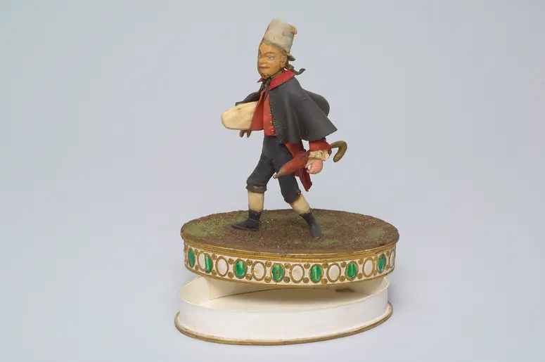 Carl Carl als Staberl - Tragantfigur, Verweis auf Stücktitel: Staberls Reise-Abenteuer